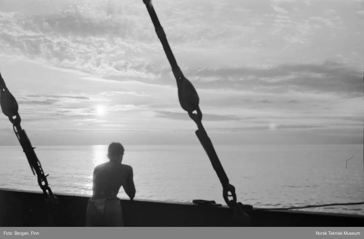 En person som betrakter solnedgang fra et skip