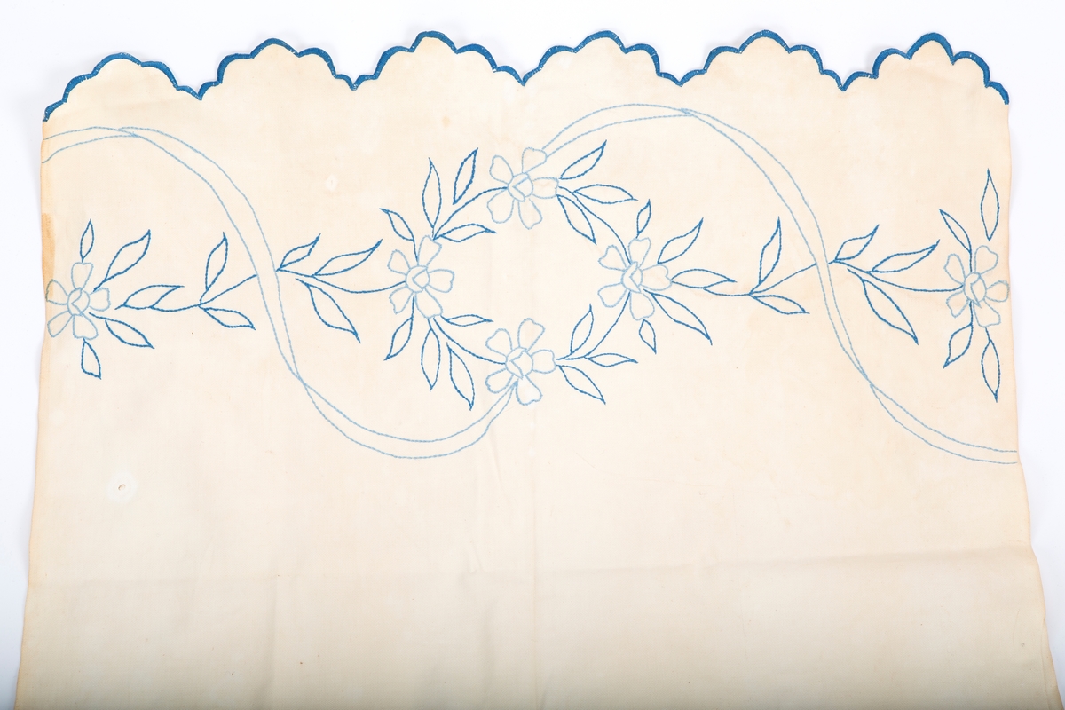 Vevet med blått konturstingsbroderi. Motiv; Blomster og ranker- Blåbroderte tunger i hver ende. Fabrikkert