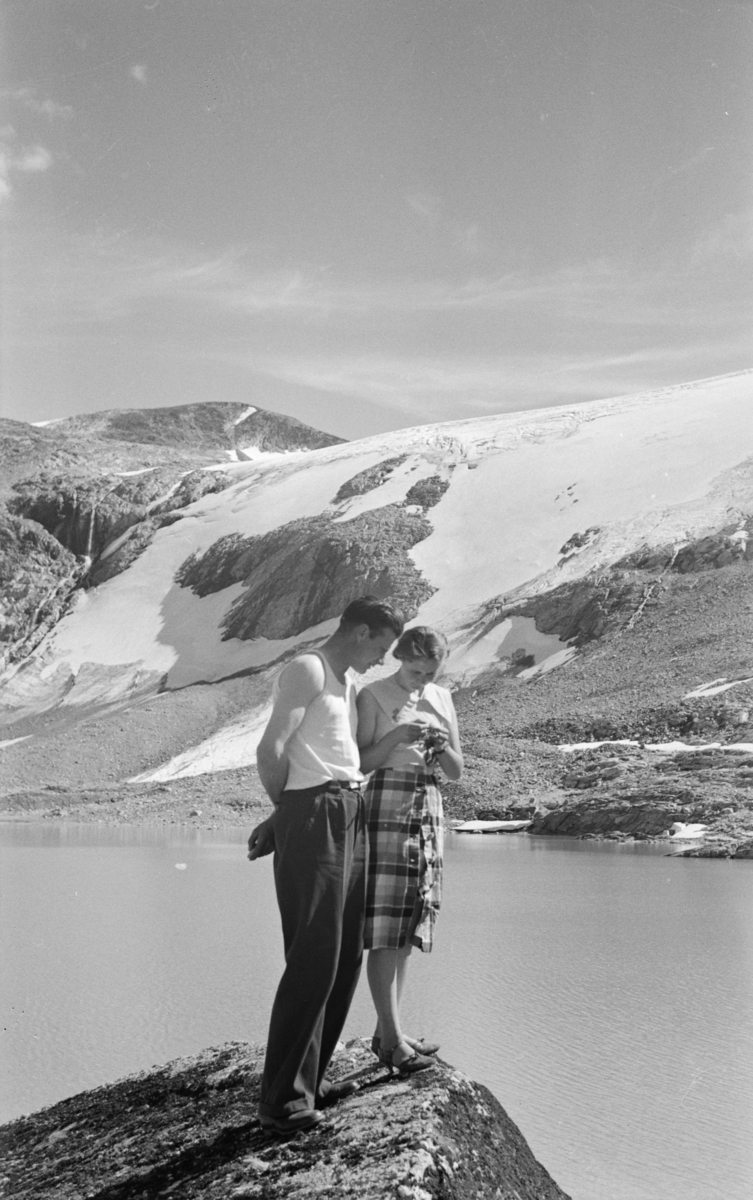 Kvinne og mann på utsiktspunkt i fjellet, antakelig langs veg fra Østlandet til Vestlandet