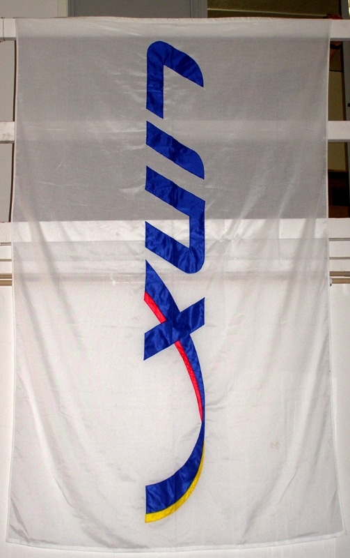 Vit flagga med påsydda blå bokstäver som bildar texten Linx.
I slutet av texten är x:et rött på undersidan och gult på ovansidan.

I delen av flaggan som är närmast flaggstången sitter en vit lina med öglor av plast i vardera änden.
