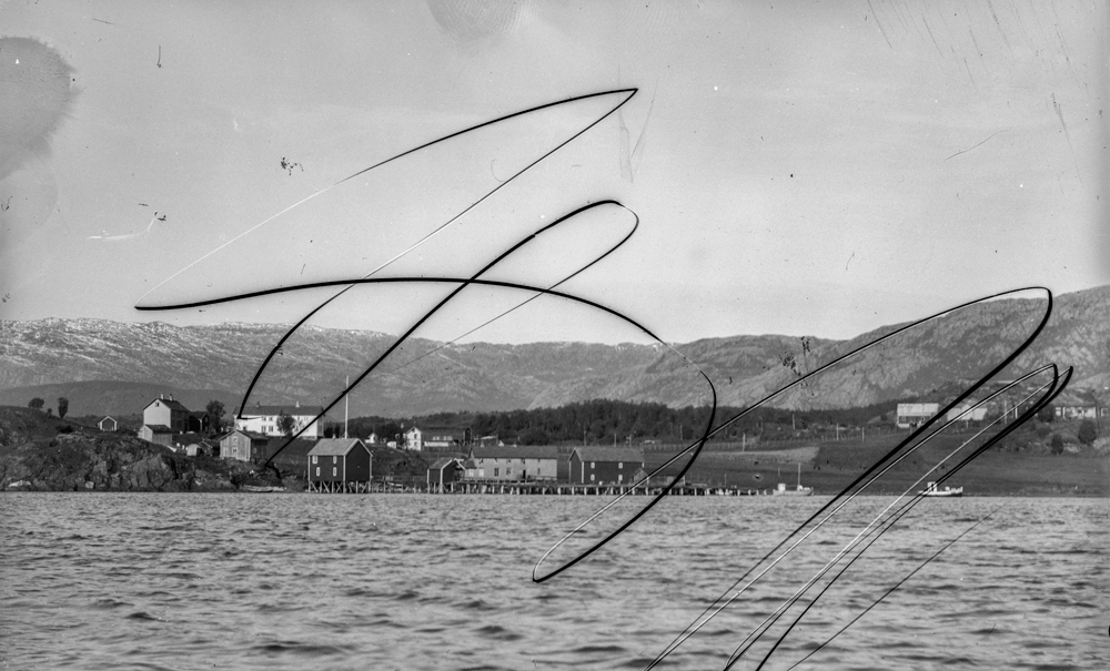 Leirfjord, Nedre-Leland. Bergh-gården med Bergh-brygga (museum) og Øverhaugen med Simsøfjellet bak. Sett fra sjøen.
