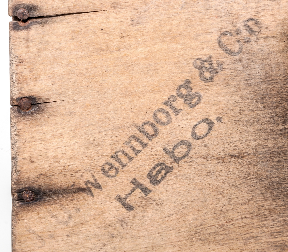 Bärplockare. Trälåda med botten av svängda järntenar (kam). En kortsida öppen och motstående sida av läder. Handtag på ovansidan. Text; "Wennborg & C:o Habo. Patent".