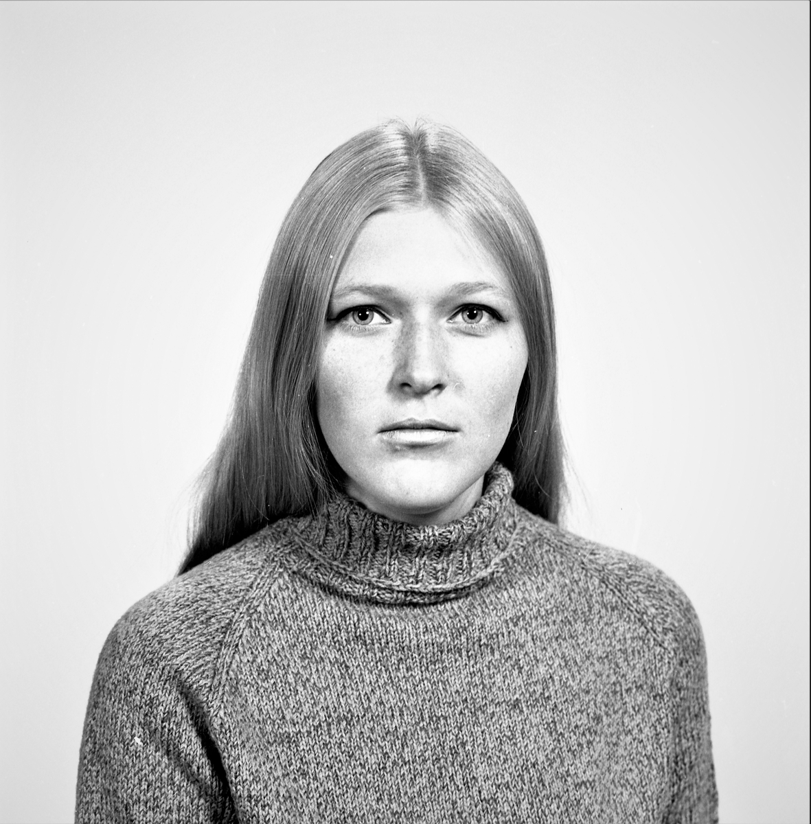 Portrett. Ung kvinne med langt mørkblondt hår i mørk flerfarget høyshalset strikkegenser. Bestilt av Else J. Stava. Øvregt. 199