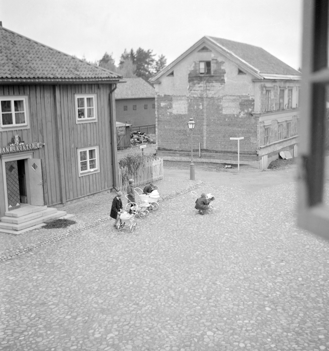 Vy över Kryddbotorget i friluftsmuseet Gamla Linköping. Närmast till vänster ligger det så kallade Landshövdingehuset, uppkallat efter att byggnaden en tid fungerade som bostad för länets ståthållare. Från 1954 är huset placerat i rådande läge och inrymmer ett bankmuseum. I fonden ses Sundströmska gården som vid tiden nyligen flyttats från Nygatan 52 för att i Gamla Linköping fungera som bostad.