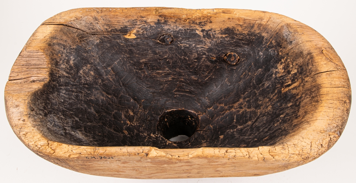 Tunntratt av trä, avlång med kort naturvuxen hals. Svart beläggning på hela insidan. I övrigt omålad.
Längt 41 cm, bredd 22 cm. Höjd 19 cm.
Undersidan ristad: S.SS 1745.