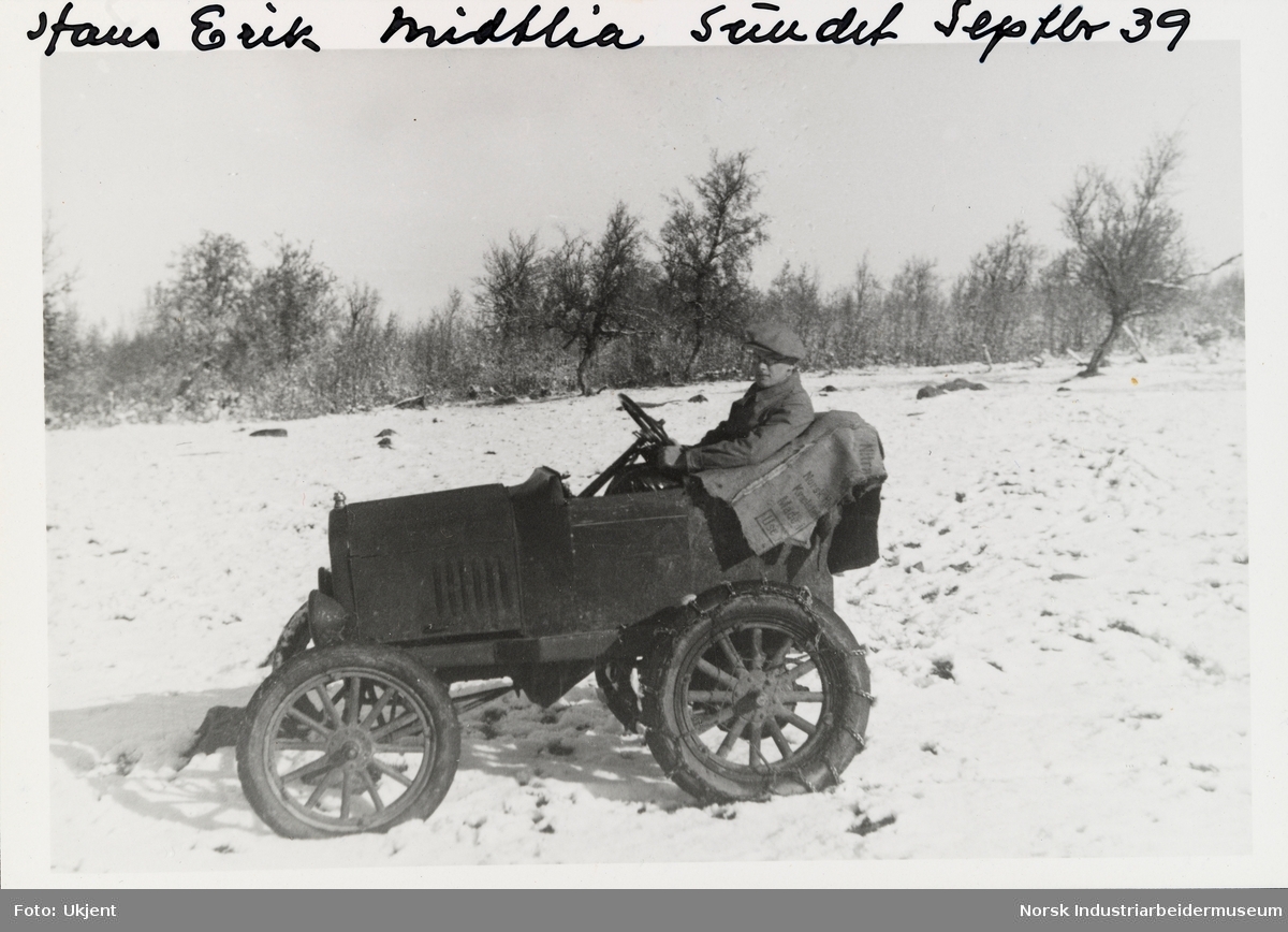 Hans Erik Midtlia, Sundet, Møsstrond. Mann med sikspens sitter i et åpent kjøretøy i et snødekt landskap. Kjøretøyet har kjetting på bakhjulene. Forkortet og modifisert Ford T 1920-24.