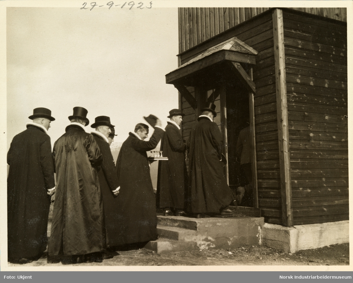 Innviing av Møsstrond kirke. Prester med hatt, pipekrage og messeklær bærer kirkesølv på vei inn i kirken