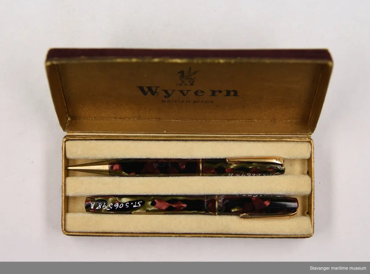 To penner i rødt, svart, grønt og messing. De ligger i en rød og gull eske, med en dragelogo og påskriften: Wyvern, made in England.
