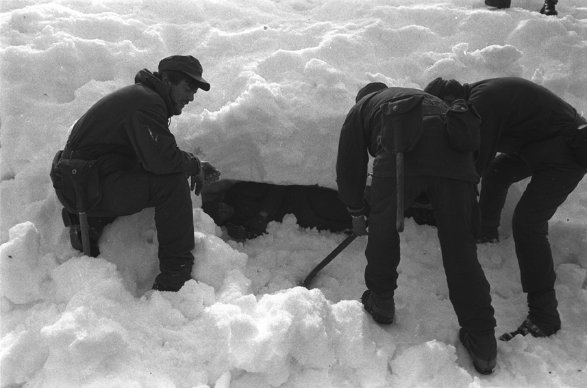 Tre befalsskolelever graver frem en markør fra en snøskavel.