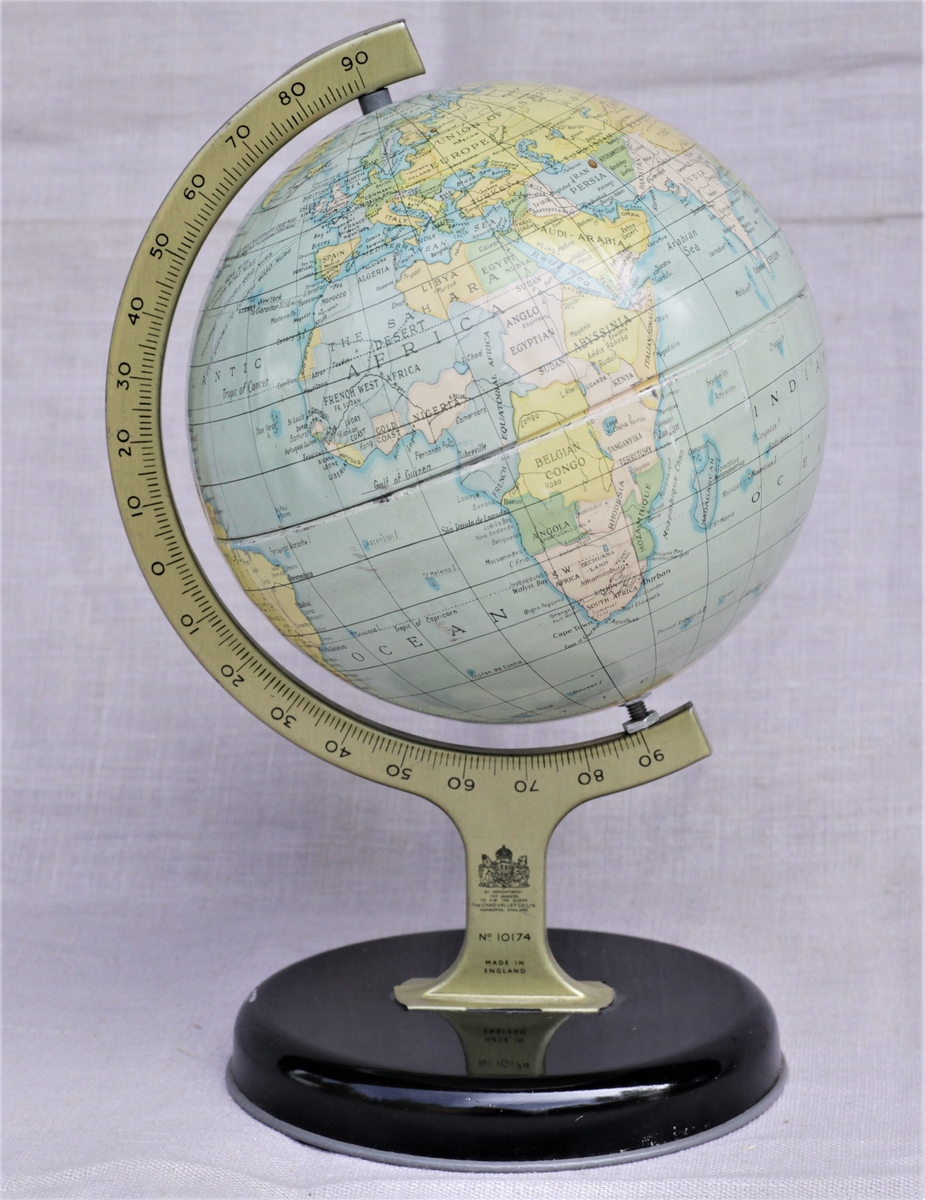 Globus stående på et stativ med svart sokkel.  Lengdegradmåler i  gullaktig farge.