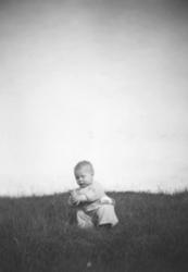 Et spedbarn fotografert ute på et jorde. Person og sted er u