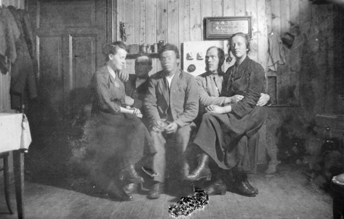 Gruppebilde av fem personer i en stue - to kvinner og tre menn