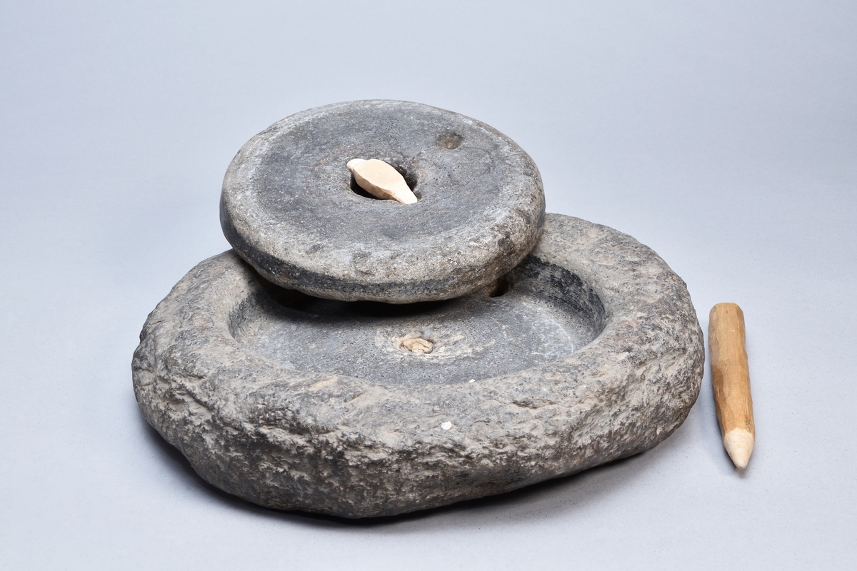 Snuskvarn av sten, rund, i två delar. Överliggaren med två hål, det ena för draghandtag. Underliggaren med ett hål.