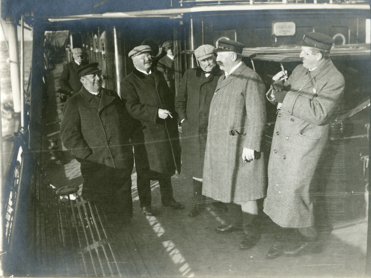 Bildtext: " 'Rökrumslaget' (Ekdahl, Ericsson, Lindström, Lundgren och Tham."
En skara män på däck under sjögång.