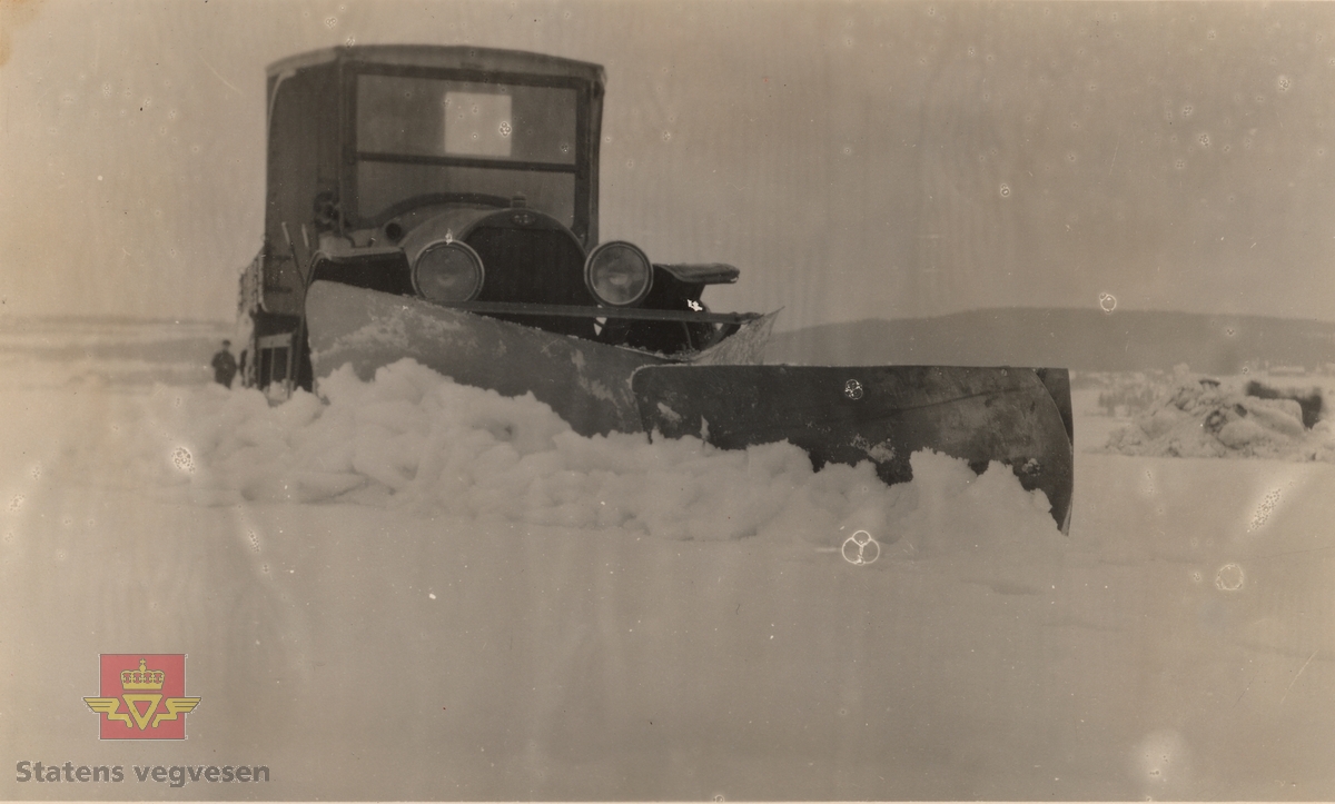 Øveraasens forplog påmontert Opel lastebil med bevegelig stykke foran plogen. Fra Øveraasens Motorfabrikk & Mek. Verksted. 
Opel var uvanlig som lastebil i Norge så tidlig, dette er en bil produsert før 1925. Opplysninger til kjøretøyet gitt av Asbjørn Rolseth. 
 
Ref. til "Meddelelser fra Veidirektøren", Nr. 10- og Nr. 11-1931: "Snerydningen på våre veier vinteren 1930-1931".
Ref. til "Meddelelser fra Veidirektøren", Nr. 3-1930,  "Snebrøytingsforsøk med 6-hjulere," av overingeniør N. Saxegaard.