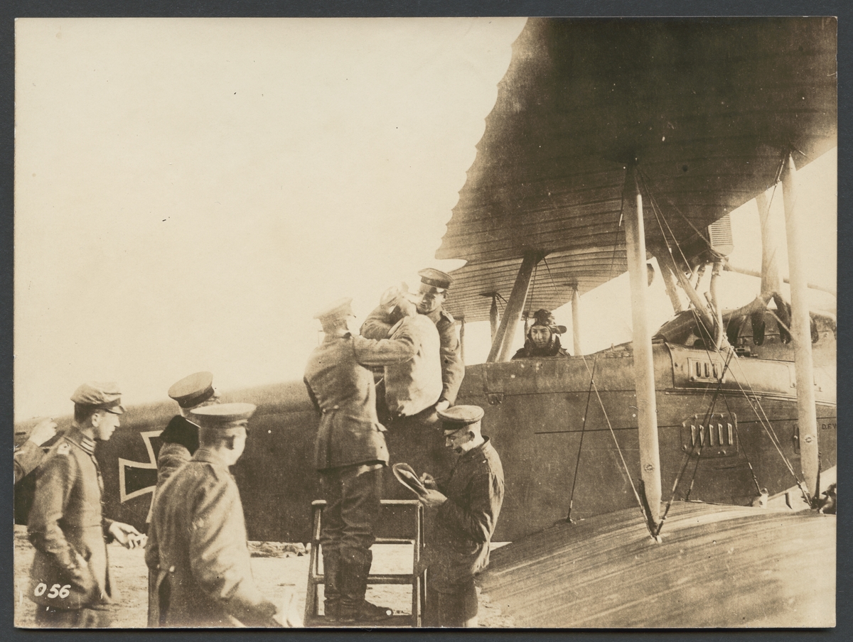 Bilden visar hur flera män i uniform lastar postsäkar ombord på ett flygplan.

Originaltext: "Brevsäckarna tagas ombord på flygmaskinen."