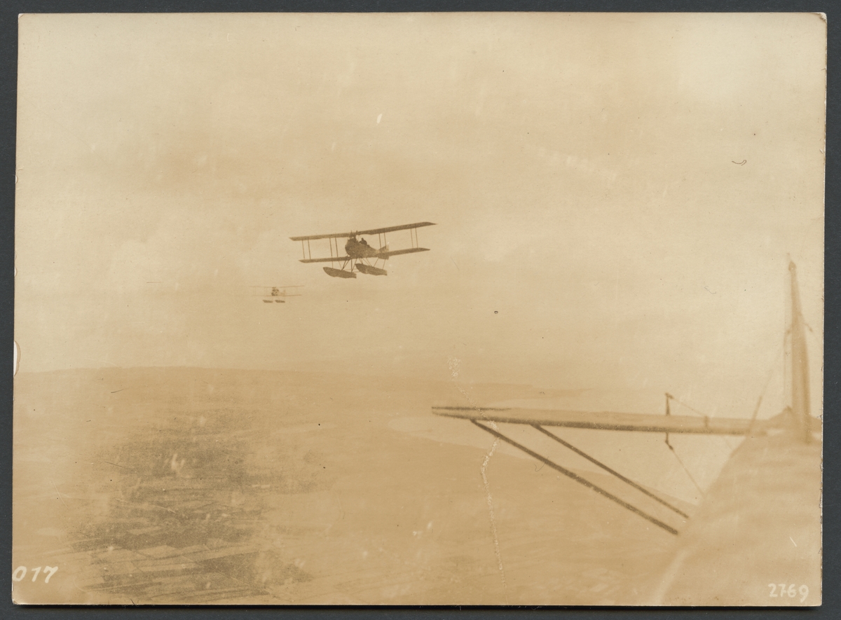 Bilden visar flygning av tre sjöflygplan längst kustlinjen.