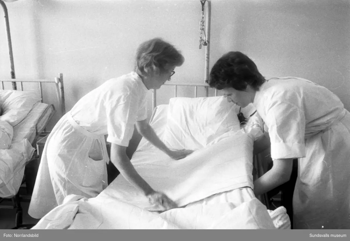 Reportage i Dagbladet 1961 från Sundsvalls lasarett, kirurgavdelningen. Reportern Catja på tidningen praktiserar som sjukvårdsbiträde och vägleds av biträdet Birgitta Modin.
