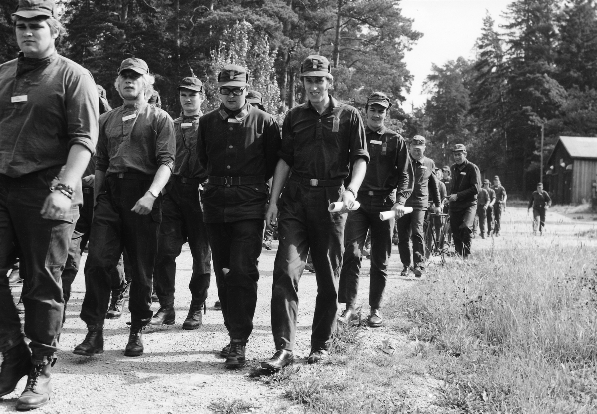 Förevisning avseende exempel på ingripande vid incident, den 19 augusti 1971.
Kompanierna marscherar till Lötgärdet där förevisningen skall ske.
Befälen på bilden är från vänster fanjunkare Tage Berglund, sergeant Bernt Sandell, överfurir Björn Pettersson (senare Stenman) och bakom honom fanjunkarna Rolf Bengtsson samt Yngve Pettersson.