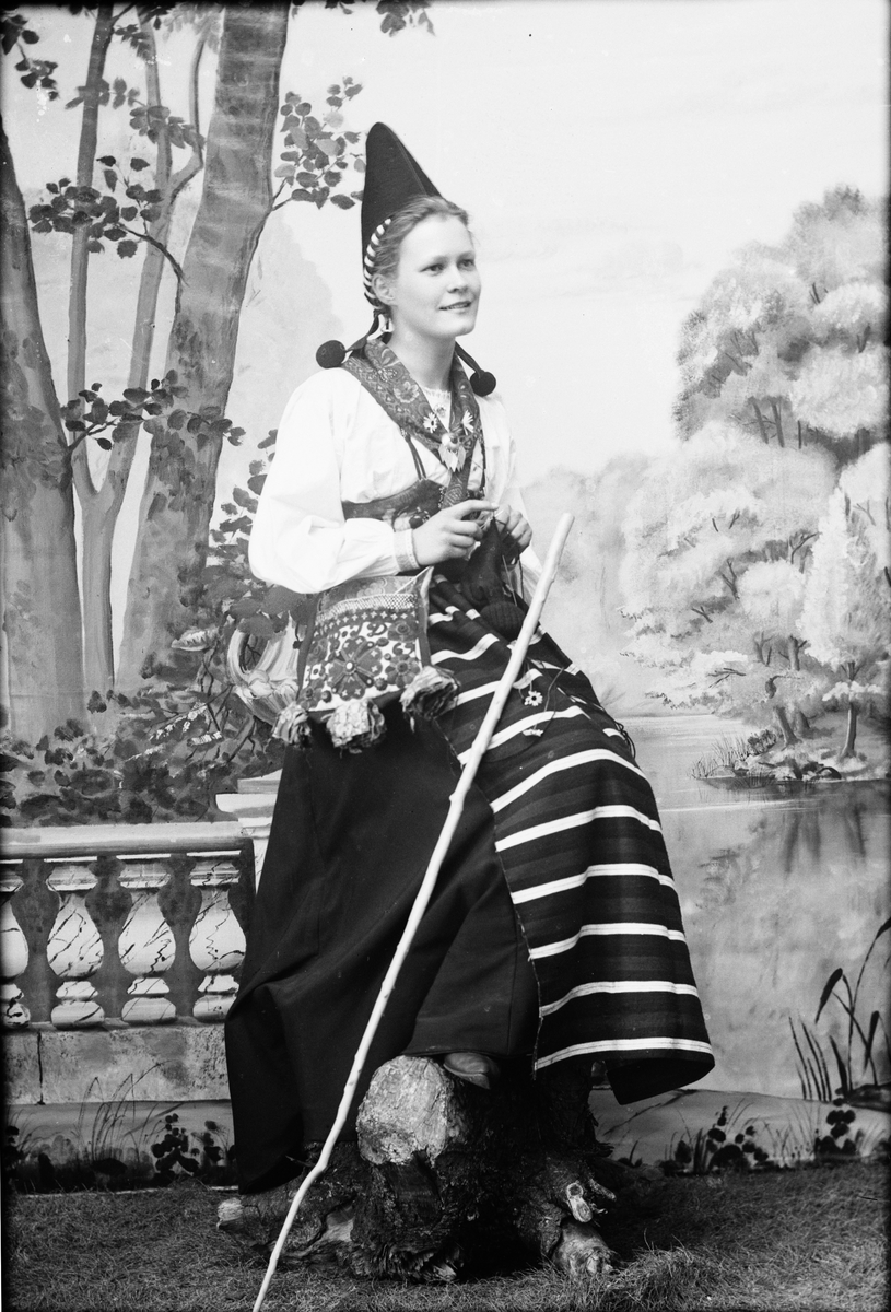 Ateljéporträtt - kvinna klädd i folkdräkt stickar, Dalarna