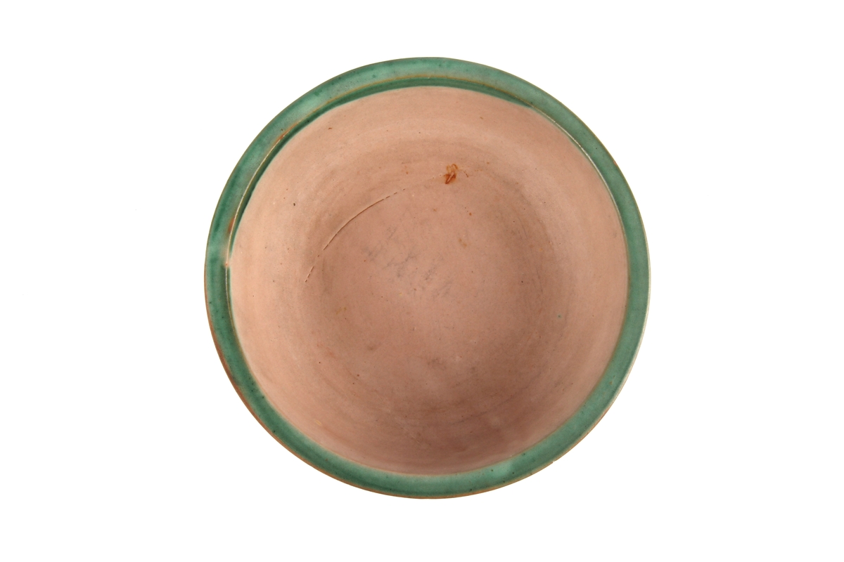 Glasert keramikkskål med grønn kant.