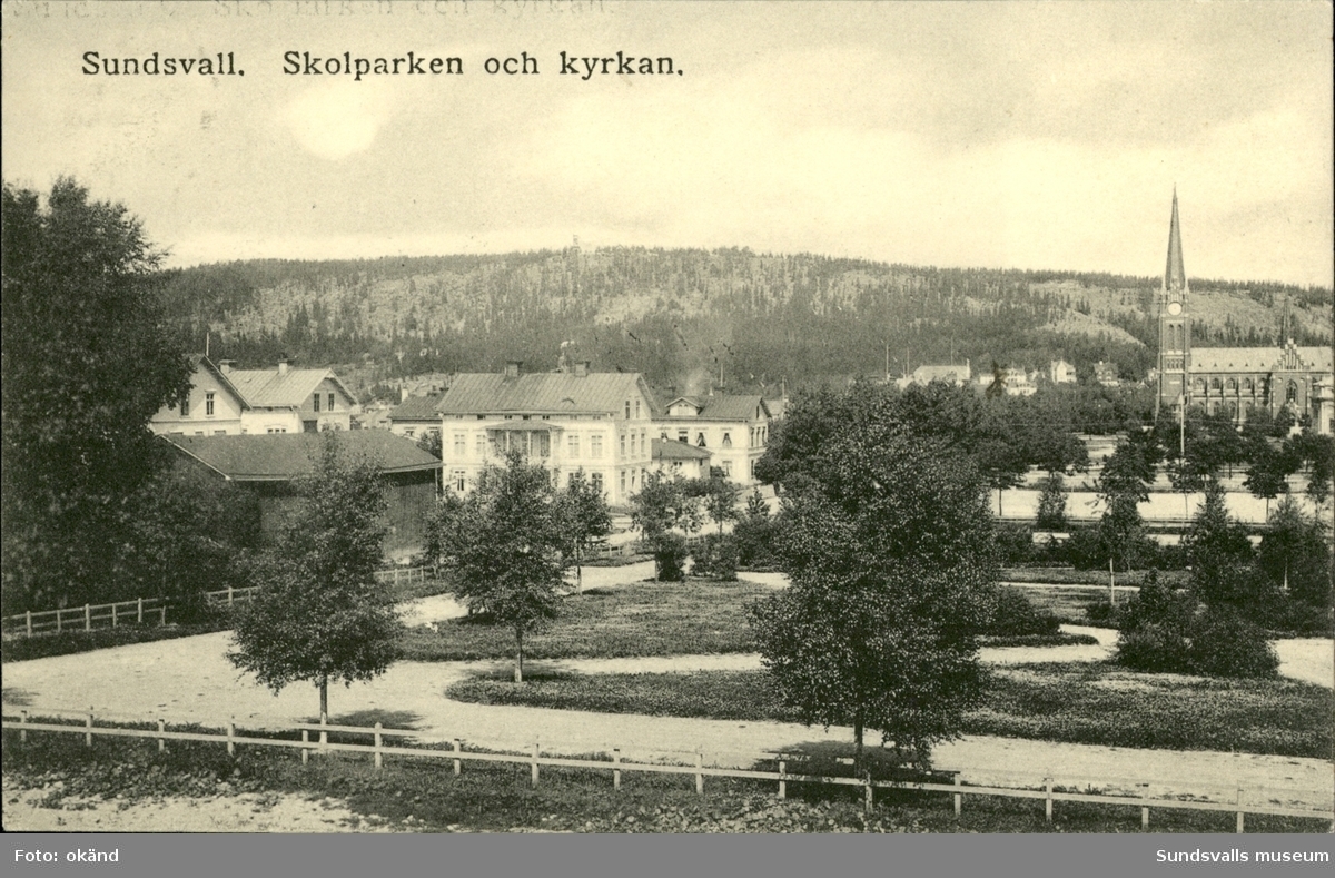 Vykort med motiv över Gustav Adolfs kyrka och skolparken.