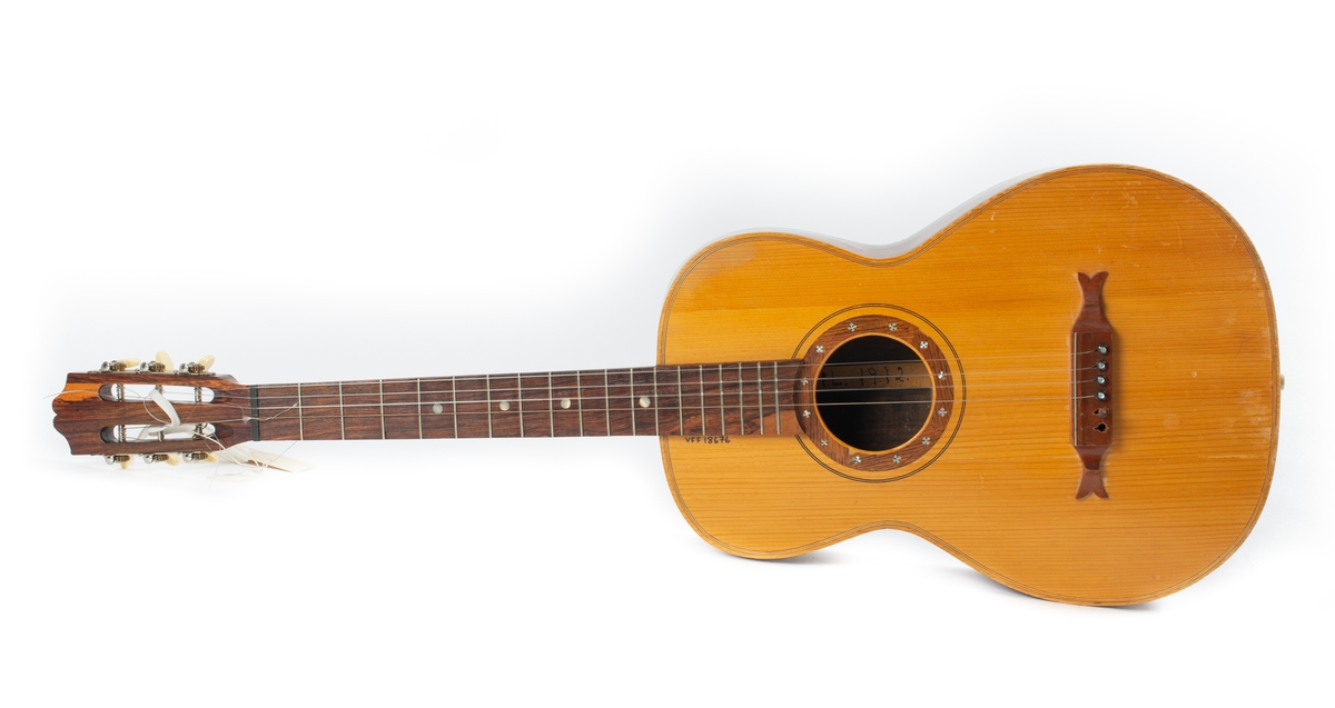 Gitar, lys kasse, mørkere brun hals, 4 strenger,  inne i kassen påskrevet:" I.L. 1972"