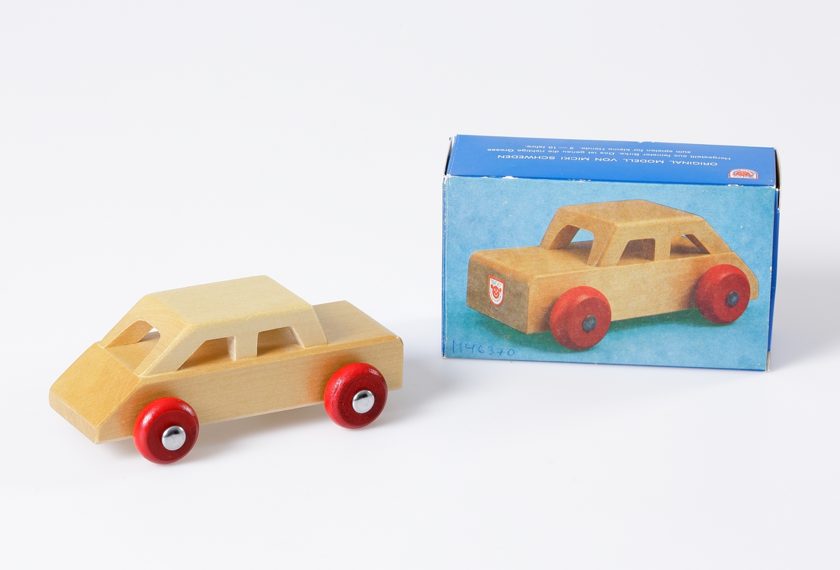 Fernissad bil (Sport Coupe) med röda hjul. Den består av en platta med fastlimmat figursågat tak. Den är starkt sluttande bakåt. Hjulen är utanpåliggande. Bilen är förpackad i en blå pappkartong med bild på och text på tyska och engelska.

Inskrivet i huvudkatalog 1982.