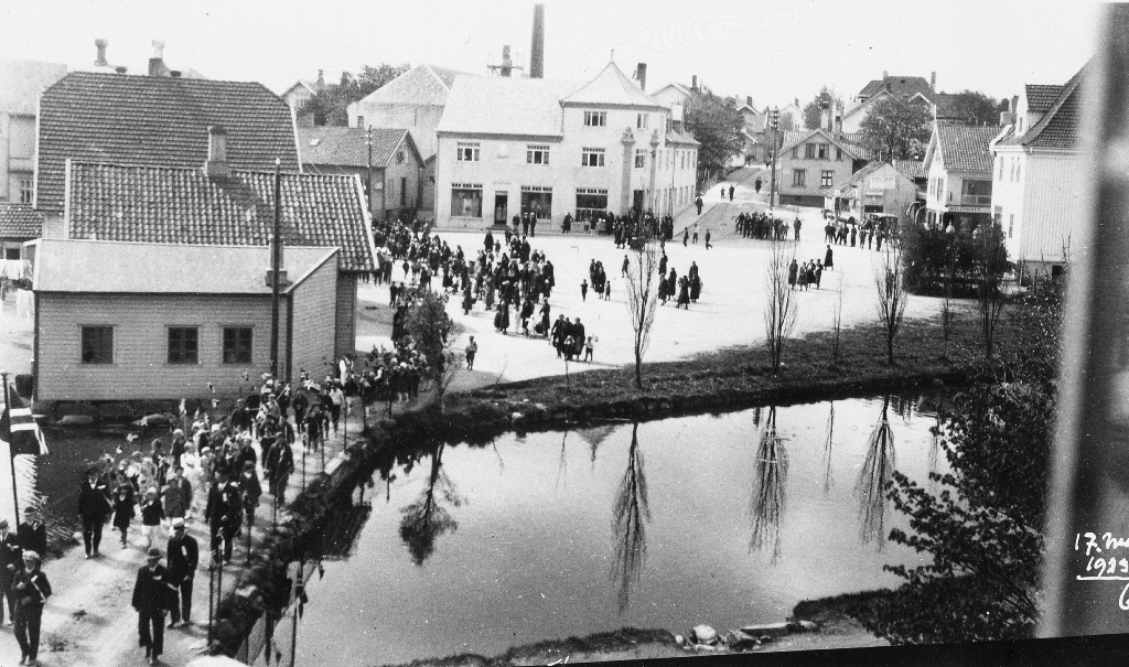 17. mai-toget på brua over Mølledammen i 1933. I bakgrunnen Torget med Jæren Forbruksforening/Domus.