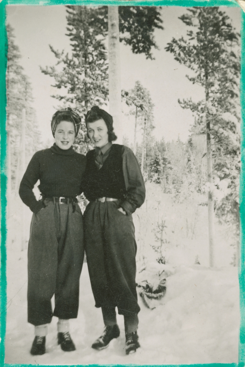 Porträtt av luftbevakare Karin Nordberg och Karin Olsson stående utomhus, vintern 1942. Vid luftbevakningsstationen för 91:a ls-kompaniet i Tellejåkk, Kåbdalis under beredskapsåren.