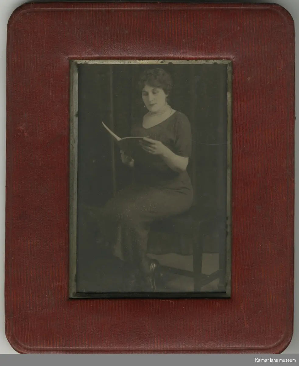 En kvinna sitter på en bänk och läser.