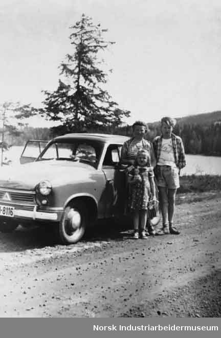 Familie stående foran bil ved Sønstevann. Bilen er av merket Lloyd, produsert av Borgwardkonsernet.
