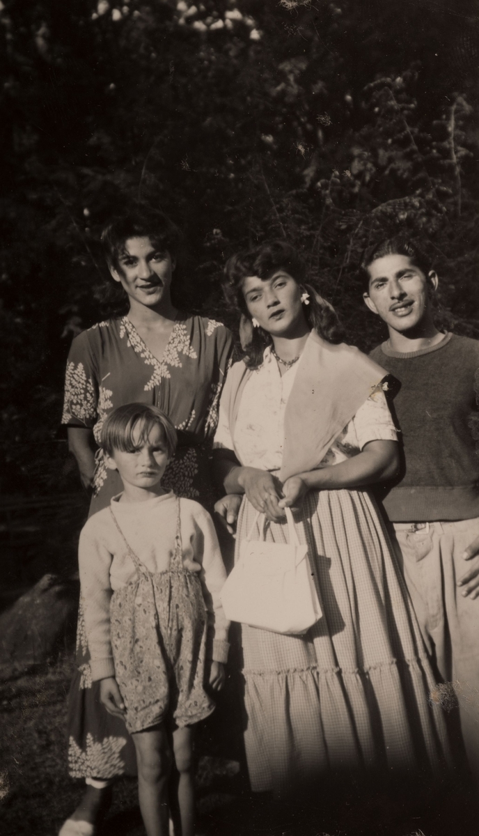 En romsk familj är samlad för fotografering, lördagen den 12 augusti 1950 i Stadsparken i Falun. I bakgrunden syns buskar och träd.