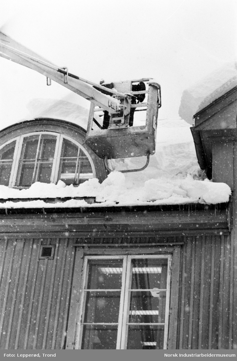 Taket på Rjukan Politikammer ryddes for snø.