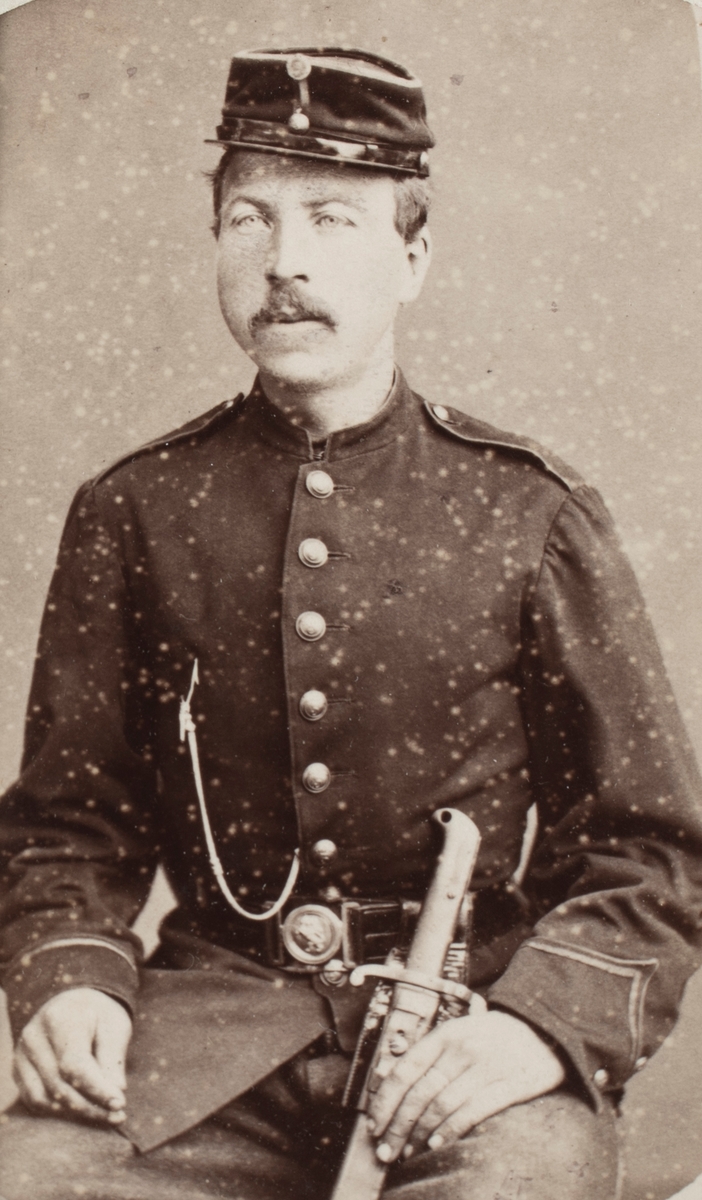 Portrettfotografi av en mann med uniform i fotoatelier.