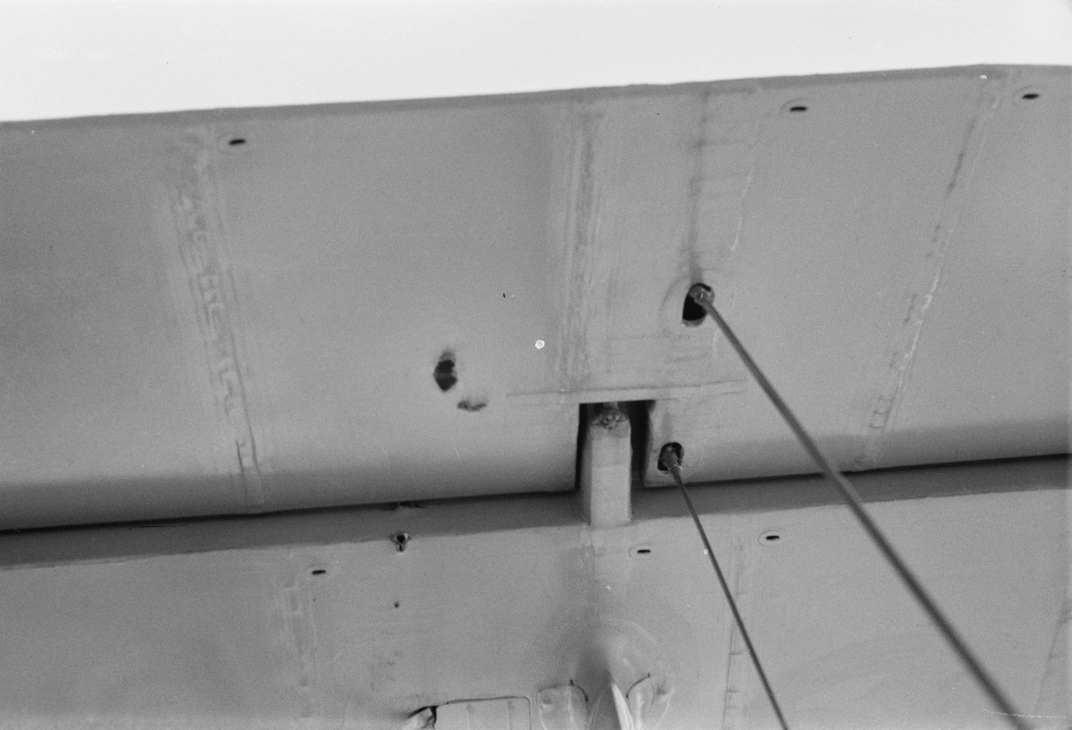 Kulhål i vinge på flygplan Gloster Gladiator gul J, efter beskjutning i luftstrid den 7 mars 1940. Vid F 19, Svenska frivilligkåren i Finland, 1940. Serie om 5 bilder.