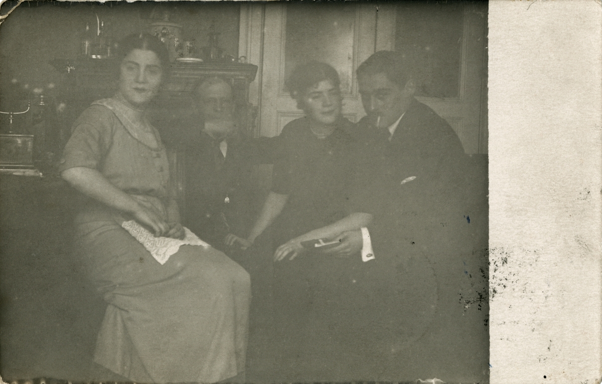 Julia (ytterst til venstre) og Victoria (nr. 3 fra venstre) sammen med to ukjente herrer.  Postkortet er skrevet på baksiden, og poststemplet Moskva, 03.01.1913.