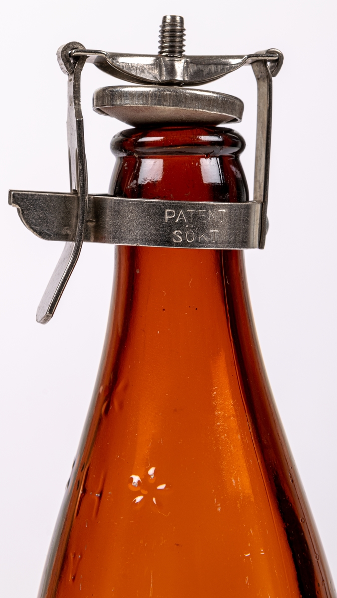 Flaska. Brunt glas. Patentkork, metall. Etikett: "PILSNER KLASS II GEFLE" m.m.
A.B. Gefle förenade bryggerier, Gefle.