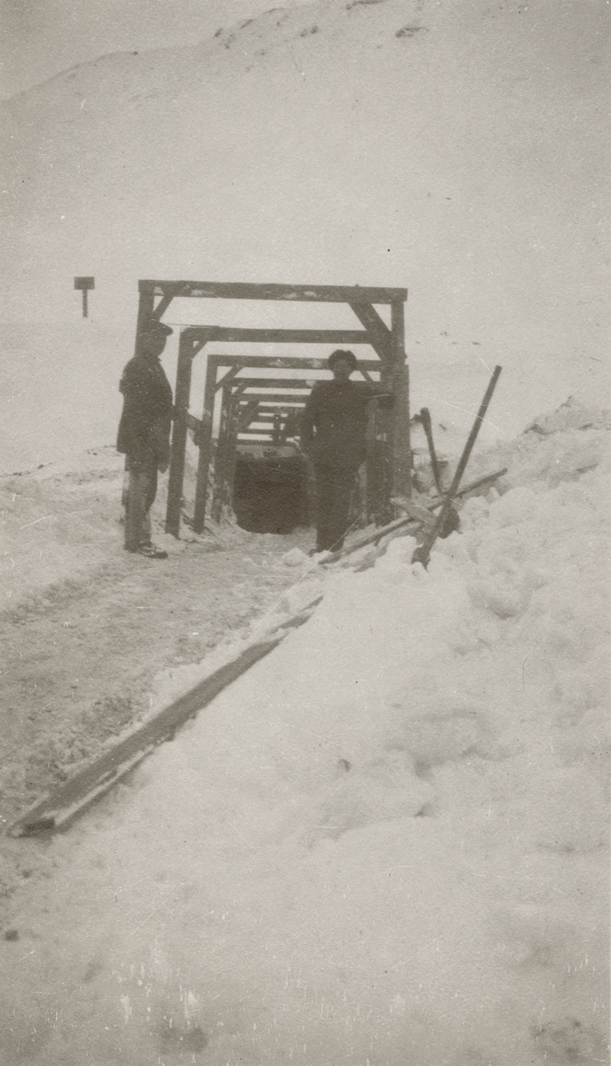 To menn står ved inngangen til ei kullgruve i Kings Bay.