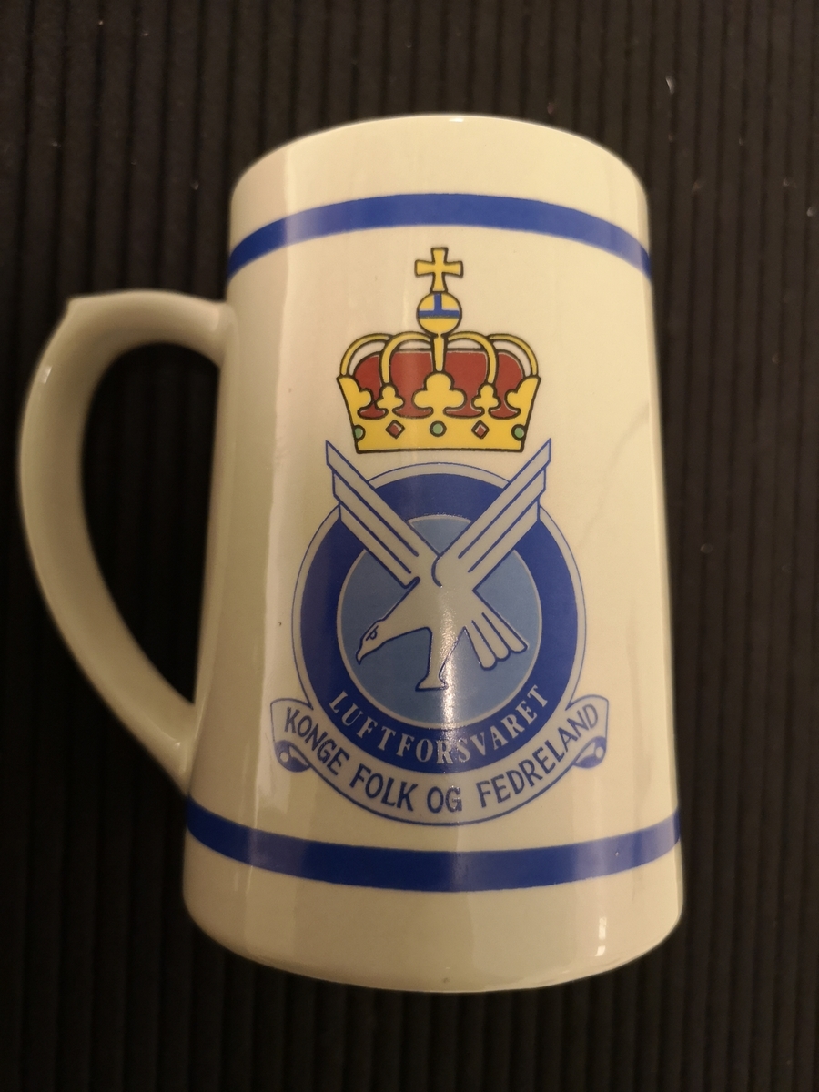 Luftforsvarets emblem.
Emblem Blokkhus og tekst "Kunnskap gir Styrke"