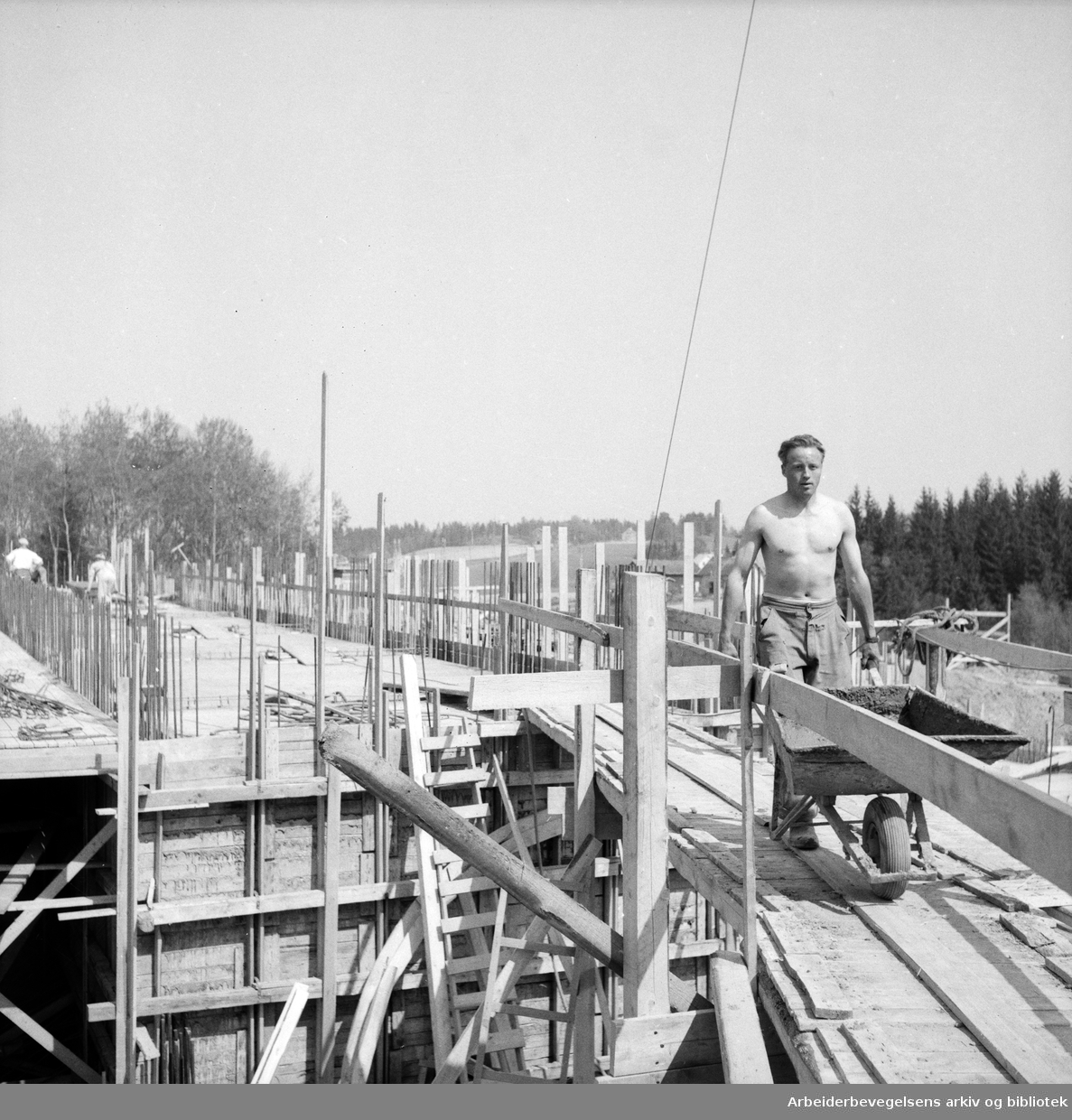 Mann med trillebår. Bygningsarbeider. Antatt Oslo. 1955 - 1960.