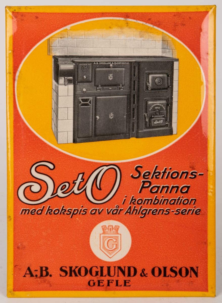 Reklamskylt för "SetO Sektionspanna i kombination med kokspis av vår Ahögrens-serie"
Plåtskylt med baksida av papp. Orange och gul med motiv av järnspis.