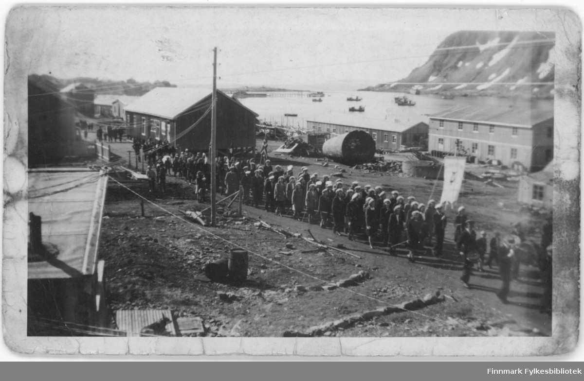 17. mai tog og feiring i Nordvågen i 1948. Vi ser gamle Samvirkelaget, brakka til venstre i bildet. Og Olaf s. Olsens fiskebruk.