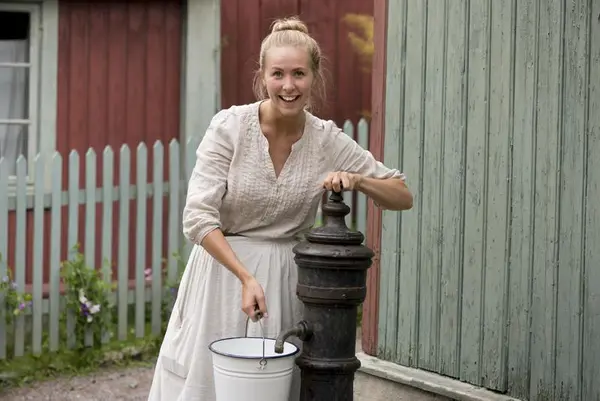 Husmor på Enerhaugen henter vann ved vannposten