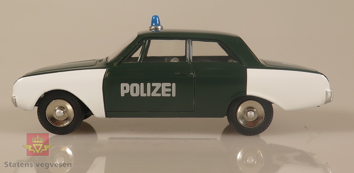 Hvit og grønnfarget politibil, med polizei skrevet på sidene av bilen.