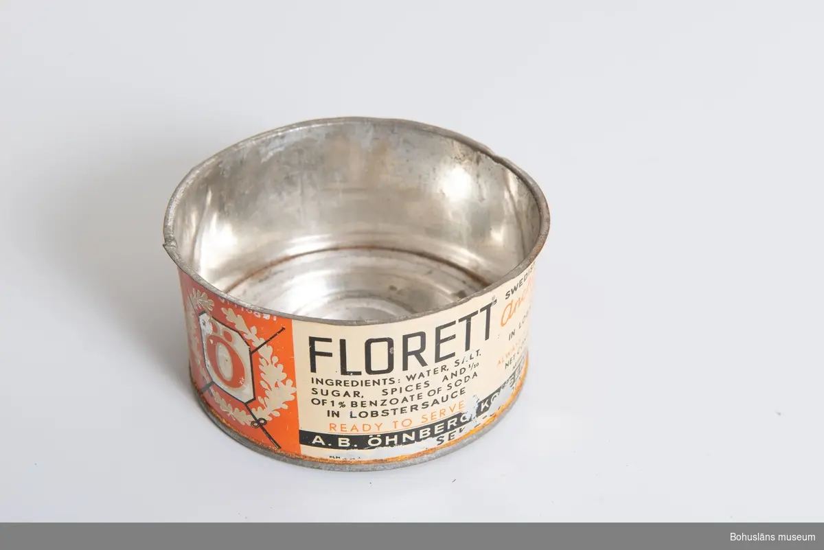 Konservburk för: "Florett anchovis sprats in lobstersauce".
Röd och vitlackad burk med engelsk text. Från Öhnbergs konservfabrik.
