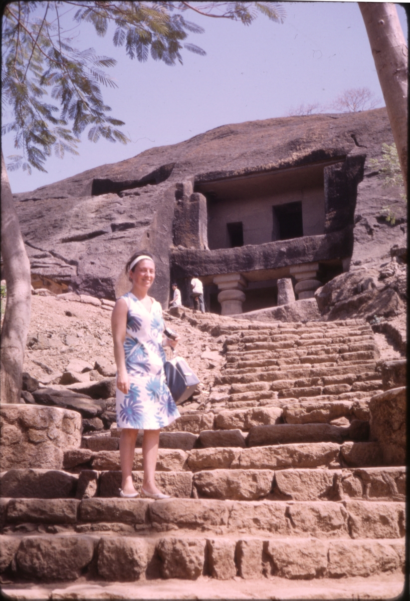 Kvinnelig turist i trapp, opp mot bygning som er skåret ut i fjellside. 'Sagafjord' Around The World via Africa Cruise 1966.