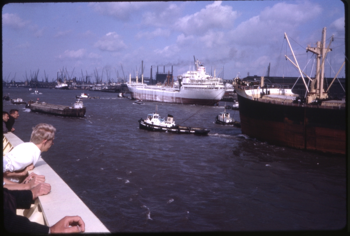 Menn ser på skipstrafikk, fra rekka på cruiseskipet 'M/S Sagafjord'. 'Sagafjord' Spring Cruise to Europe 1966.