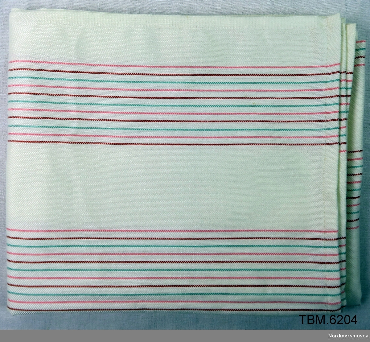 Kvitt med tynne striper i raudt og grønt. brukt som duk, men kan også brukast som gardiner.