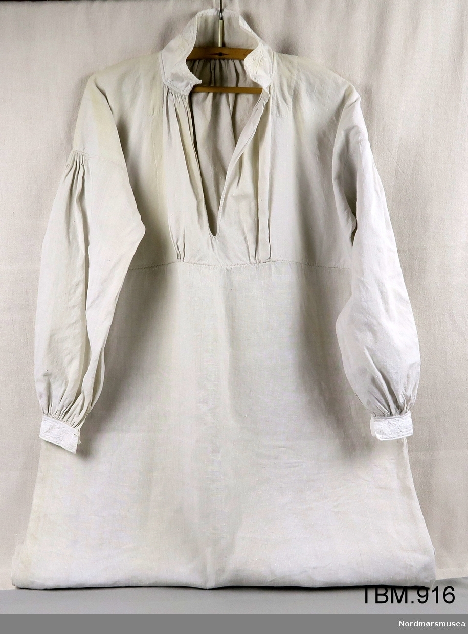 Dette er ei labbsaumsskjorte i lin. Teknikken er labbsaum, knuter, attersting, aggar og knapphullssting.
Boderi på halslinning og mansjettar.
Skjorta er spesielt lang.